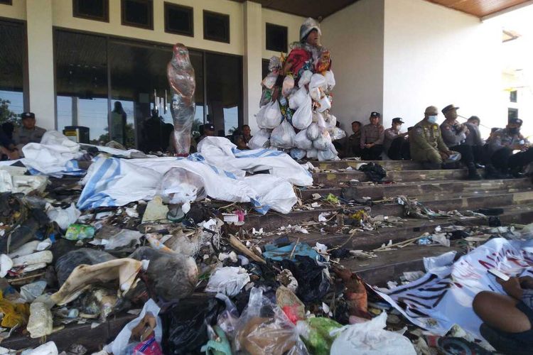 Aksi teatrikal aktivis lingkungan Tasikmalaya memakai jubah sampah dan perempuan dililit plastik bening dengan membuang beberapa karung sampah protes pencemaran lingkungan di halaman Bale Kota Tasikmalaya, Jawa Barat, Kamis (27/7/2023).