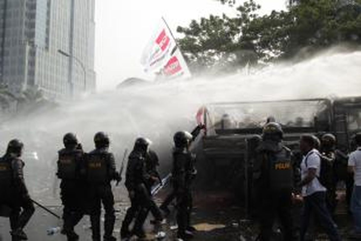 Polisi menembakkan gas air mata dan water cannon untuk membubarkan massa pendukung Prabowo-Hatta yang berusaha menerobos masuk menuju Gedung Mahkamah Konsistusi (MK) di Jalan Medan Merdeka Barat, Jakarta, Kamis (21/8/2014). Hari ini MK akan memberikan putusan atas kasus perselisihan hasil pemilihan umum (PHPU) presiden dan wakil presiden 2014. KOMPAS IMAGES/RODERICK ADRIAN MOZES