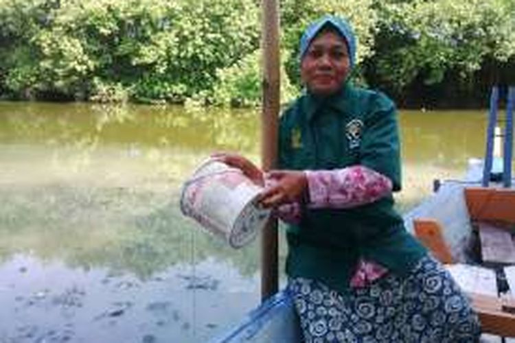 Chusniati membersihkan perahunya untuk mengais sampah di Hutan Mangrove Pamurbaya, Senin (25/4/2016)