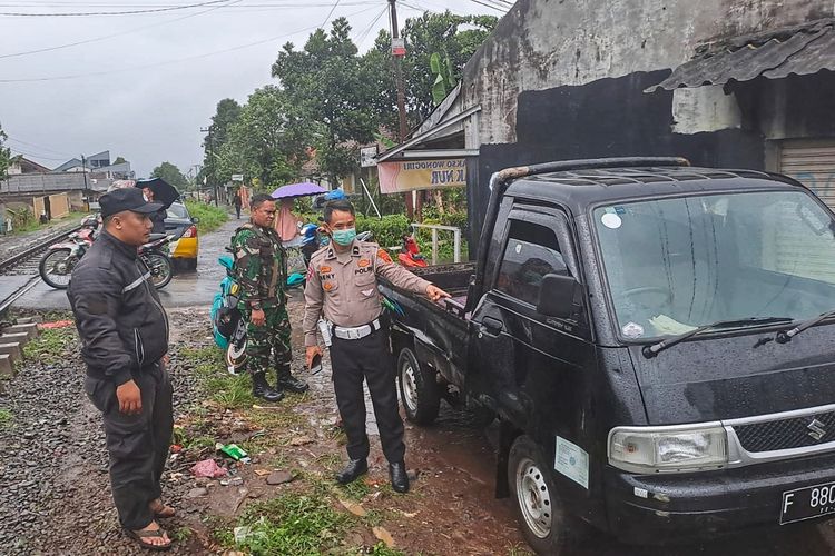 Seorang anggota Satlantas Polres Sukabumi menunjukkan kerusakan mobil yang tertabrak kereta api Pangrango di Desa Karangtengah, Cibadak, Sukabumi, Jawa Barat, Kamis (6/10/2022).