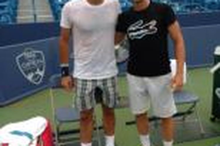Petenis Swiss, Roger Federer (kiri), berpose bersama Denis Kudla dari Amerika Serikat, saat berlatih di lapangan tenis Cincinnati, Kamis (8/8/2013).