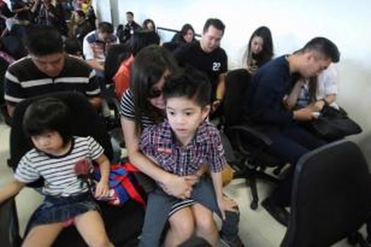 Keluarga penumpang pesawat menunggu perkembangan berita hilangnya pesawat AirAsia QZ8501 di Bandara Juanda, Surabaya, 28 Desember 2014. Pesawat AirAsia QZ8501 yang mengangkut 155 penumpang serta 7 awak, hilang kontak pada Minggu pagi, saat penerbangan dari Surabaya menuju Singapura.