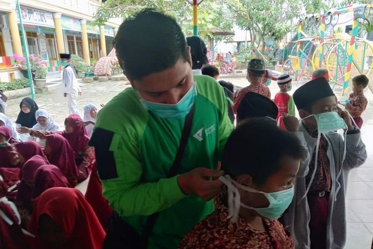 Petugas Dompet Dhuafa memberikan masker kepada anak-anak di Riau