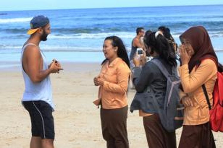 Pelajar sedang mempraktikkan bahasa Inggris dengan wawancarai turis asing yang juga peserta Pulau Merah Banyuwangi International Surfing Competition 2014, Jumat (23/5/2014).