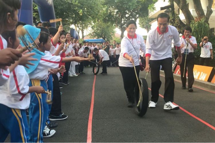 Presiden Joko Widodo dan Ibu Negara Iriana menjajal permainan tradisional Obor Ban di halaman tengah Istana Presiden, Jakarta, Jumat (4/5/2018)