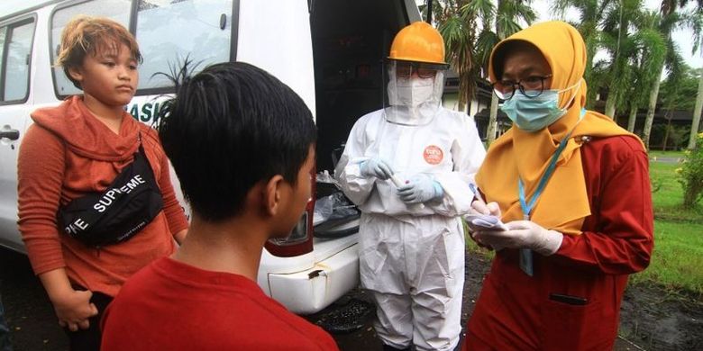 Dua petugas medis mencatat data remaja pesepeda yang terjaring razia kepatuhan penggunaan masker di Jalan Ahmad Yani, Pontianak, Kalimantan Barat, Senin (06/07).