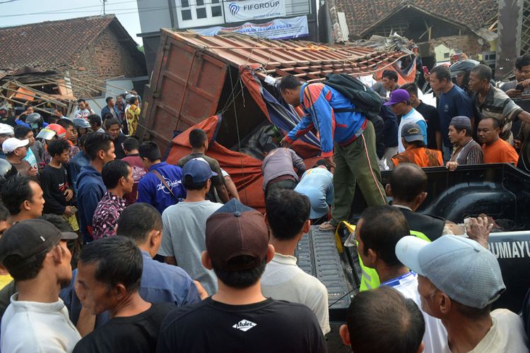 Sejumlah warga memperhatikan lokasi tempat terjadinya kecelakaan truk di jalur tengah Tegal-Purwokerto, Desa Jatisawit, Bumiayu, Brebes, Jawa Tengah, Minggu (20/5/2018). Truk pengangkut gula yang diduga mengalami rem blong tersebut menabrak enam rumah, satu kios buah, 19 sepeda motor, dua mobil sehingga mengakibatkan 11 orang meninggal dan sejumlah warga luka-luka.