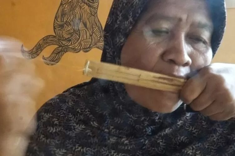 Sri Hartini memainkan alat musik rinding.