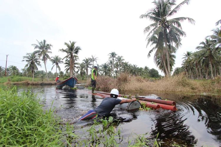 Petugas PLN berupaya mengaliri listrik dengan melintasi sungai di kawasan desa terpencil di Kabupaten Indragiri Hilir, Riau. Minggu (16/8/2020). Dok PLN-Riau/Kepri.