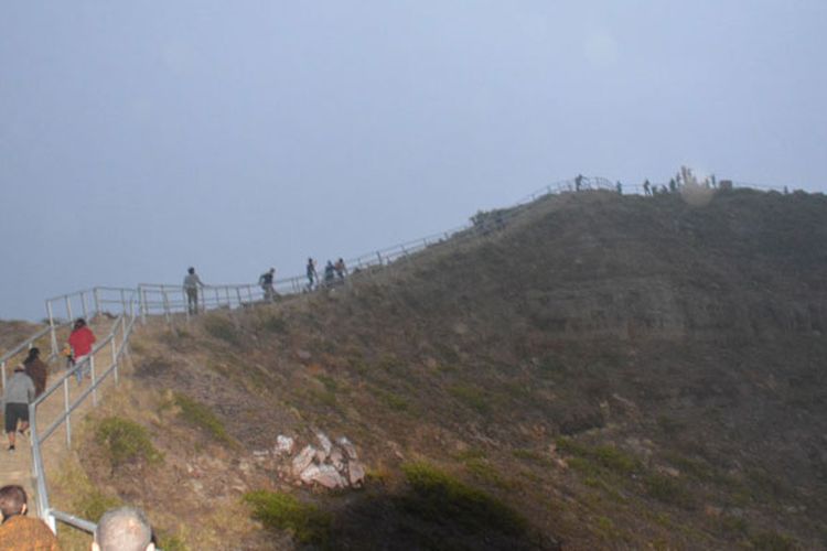 Rombongan menaiki tangga menuju ke puncak Tugu Danau Kelimutu, di Desa Moni, Waturaka, Kecamatan Kelimutu, Kabupaten Ende, NTT, Kamis (25/5/2017). Saat tiba di puncak, kabut tebal menyelimuti tiga kawah Danau Kelimutu sehingga wisatawan tak sempat melihat keunikan dan keajaiban warna air di Danau Kelimutu.