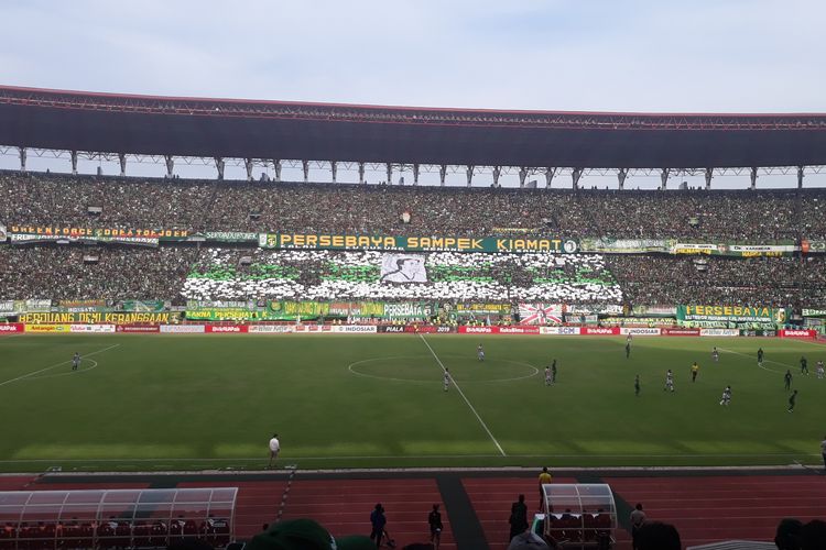 Pendukung Persebaya membentangkan spanduk bergambar Legenda Persebaya Eri Erianto. Duel Persebaya Vs Madura United di leg pertama Babak Semifinal Piala Presiden 2019 menjadi momen untuk mengenang 19 tahun mrninggalnya Eri Erianto, Rabu (3/4/2019).