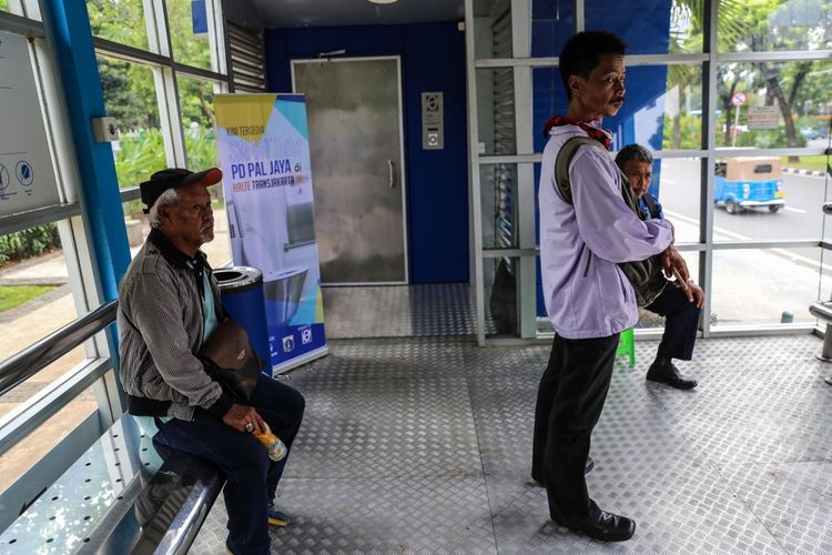 Warga saat menunggu kedatangan bus transjakarta di samping smart toilet di Halte Balai Kota, Jakarta Pusat, Selasa (10/10/2017). Saat ini, baru ada dua smart toilet yang dipasang di halte transjakarta, yakni Halte Monas dan Halte Balai Kota serta kehadiran fasilitas smart toilet ini untuk meningkatkan kenyamanan pelanggan Transjakarta.