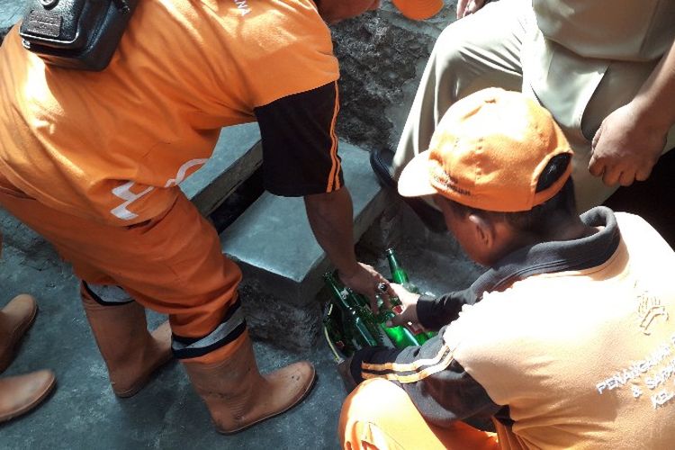 Petugas Penanganan Prasarana dan Sarana Umum (PPSU) Kelurahan Pekojan menemukan 8 botol minuman keras (miras) kosong di tangga depan musala Al-Fallah, Gang Kepiting, RT 09 RW 05, Pekojan, Tambora, Jakarta Barat pada Senin (15/10/2018). 