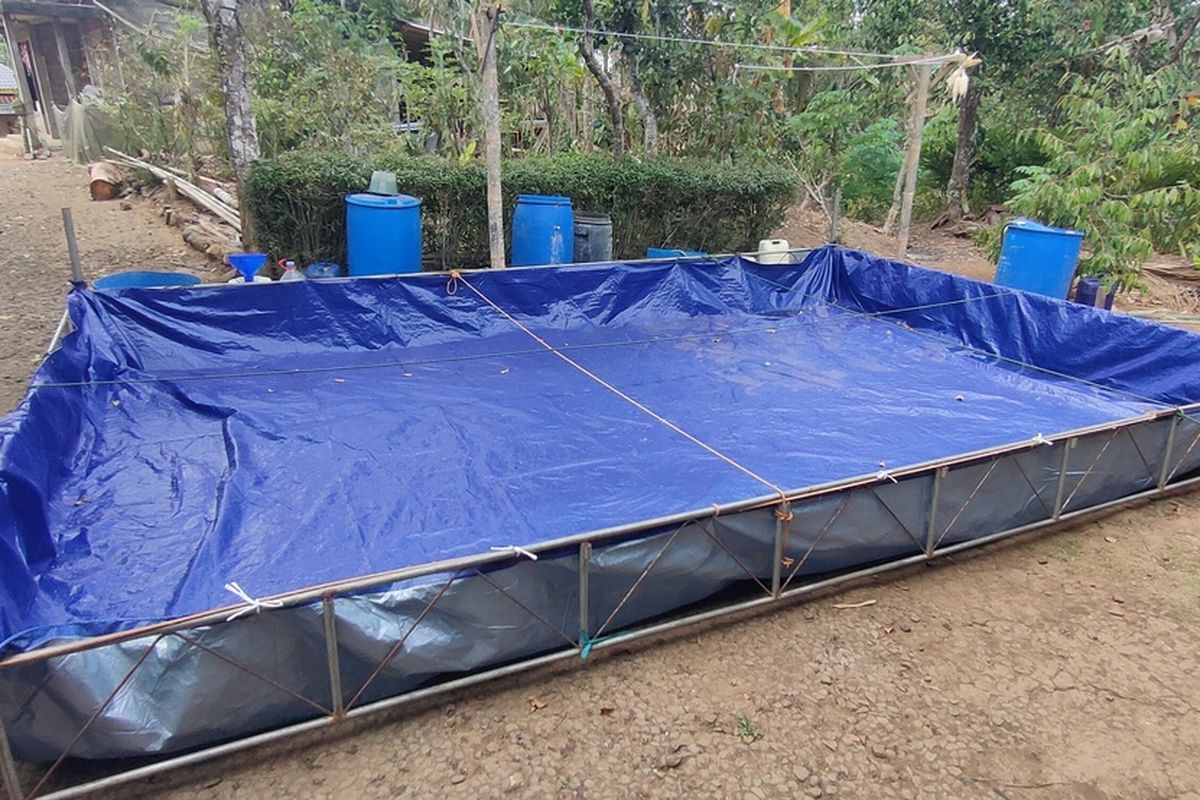 Penampungan dari terpal di Pedukuhan Ngaglik, Kalurahan Purwosari, Kapanewon Girimulyo, Kabupaten Kulon Progo, Daerah Istimewa Yogyakarta. Kolam seluas 24 meter persegi itu sudah diisi dua kali pekan lalu. Karena kebutuhan warga, air cepat sekali habis dan penampungan kembali kering. Warga meletakkan beberapa ember dan jeriken kosong di sekeliling kolam, menunggu penyaluran air bersih berikutnya.