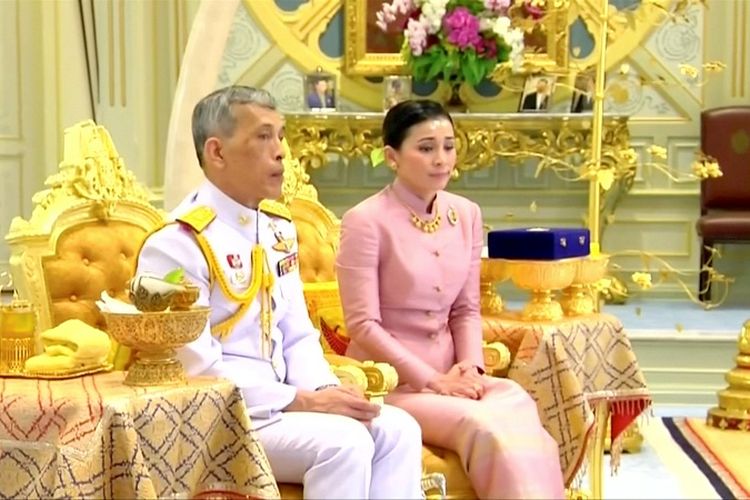 Raja Thailand Maha Vajiralongkorn duduk bersanding dengan istrinya Suthida Vajiralongkorn yang kemudian bergelar Ratu Suthida dalam pesta pernikahan mereka di Bangkok, Rabu (1/5/2019). 