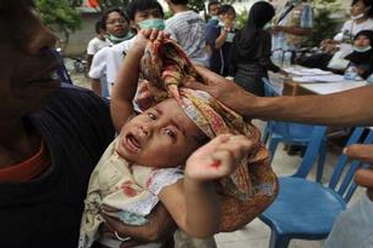 Seorang balita pengungsi mendapatkan perawatan setelah terluka saat bermain di barak pengungsian Desa Tlogo, Kecamatan Prambanan, Klaten, Jawa Tengah, Sabtu (6/11/2010). Anak-anak korban bencana selain rawan mengalami trauma juga rawan sakit dan terluka saat hidup di pengungsian.