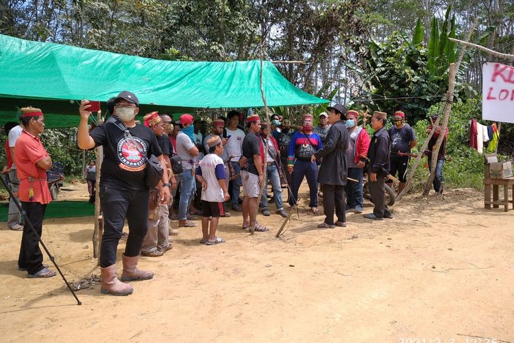 Masyarakat Adat Dayak Long Wai saat menggelar aksi damai menutup akses pengangkutan CPO dan buah sawit di wilayah adat Dayak Modang, Kilometer 16, Desa Long Bentuk, Kecamatan Busang, Kabupaten Kutai Timur, Kalimantan Timur, Sabtu (30/1/2021).