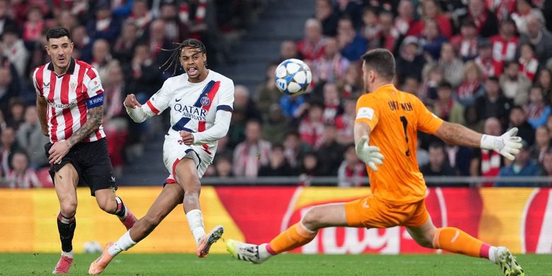 Paris Saint-Germain's French forward #29 Bradley Barcola challenges Athletic Bilbao's Spanish goalkeeper #01 Unai Simon during the UEFA Champions League league phase day 6 football match between Athletic Club Bilbao and Paris Saint-Germain (PSG) at San Mames Stadium in Bilbao on December 10, 2025.