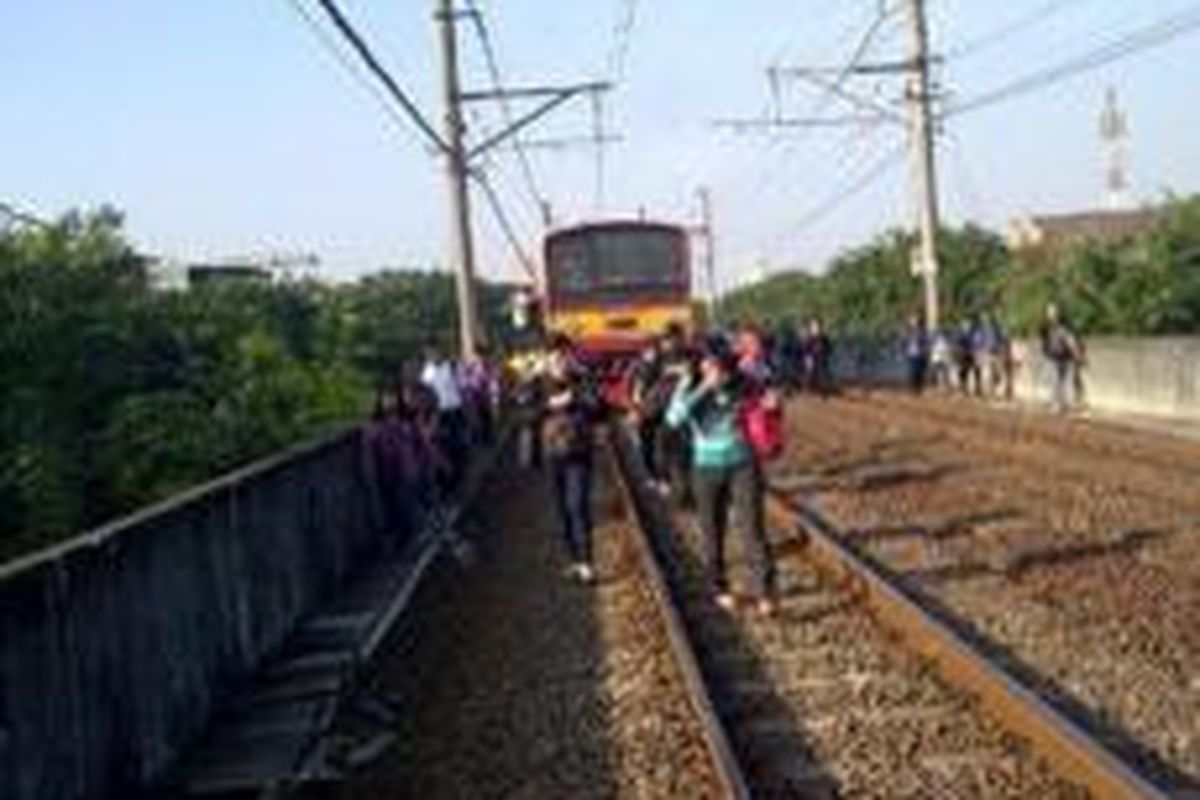 Sejumlah penumpang KRL yang turun dari kereta yang mereka tumpangi, Senin (25/5/2015) pagi. Hal ini terjadi akibat kereta berhenti terlalu lama menyusul adanya gangguan wesel di Stasiun Jakarta Kota.