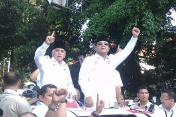 Calon Presiden, Prabowo Subianto (kanan) dan calon wakil presiden, Hatta Rajasa (kiri), berdiri melewati sun roof mobil dan melambaikan tangan kepada para pendukungnya, saat meninggalkan gedung Komisi Pemilihan Umum, Jalan Imam Bonjol, Jakarta Pusat, Minggu (1/6/2014)