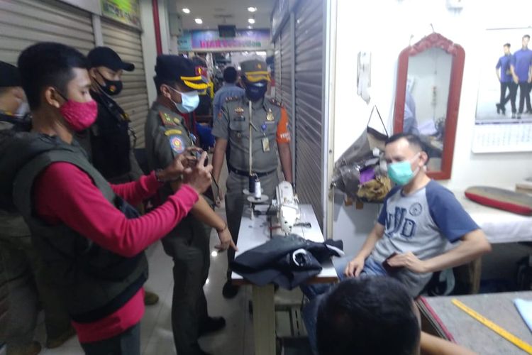 Satuan Polisi Pamong Praja (Satpol PP) menggelar operasi tertib masker di Pasar Senen, Jakarta Pusat, Selasa (12/1/2021). Lebih dari 50 orang dikenai sanksi karena tak memakai masker atau pun tak memakai maskernya dengan benar. 
