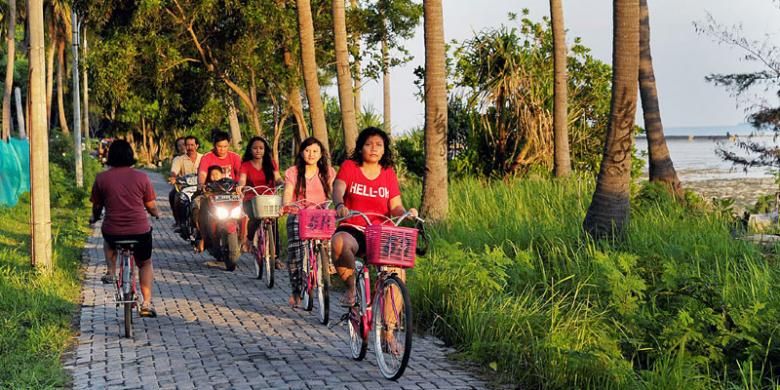 Wisatawan bersepeda menyusuri kawasan pantai di Pulau Tidung, Kepulauan Seribu, Sabtu (13/3/2015). Keindahan pantai menjadi daya tarik wisatawan untuk berkunjung ke pulau itu.
