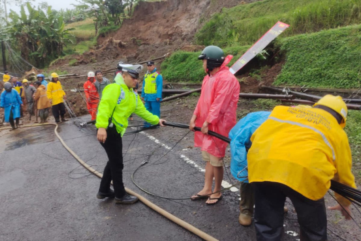 Sejumlah petugas membersihkan material longsoran yang menutupi ruas jalan Garut-Tasikmalaya di Desa Sukamaju Kecamatan Cilawu, Sabtu (28/06/2025)