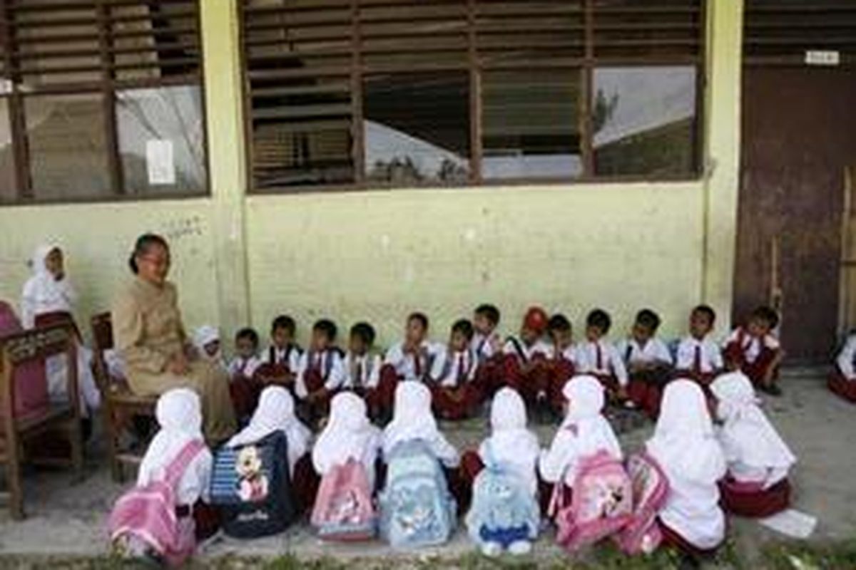 Siswa SD Negeri 14 Belanti, Kecamatan Padang Utara, Kota Padang, Suametera Barat, belajar di luar kelas, Senin (12/10). Mereka belum mendapatkan bantuan tenda darurat pengganti ruang kelas mereka yang ambruk. Kegiatan pertama sekolah difokuskan pada materi yang dapat membangun ketahanan psikologis anak untuk menghapus trauma. 