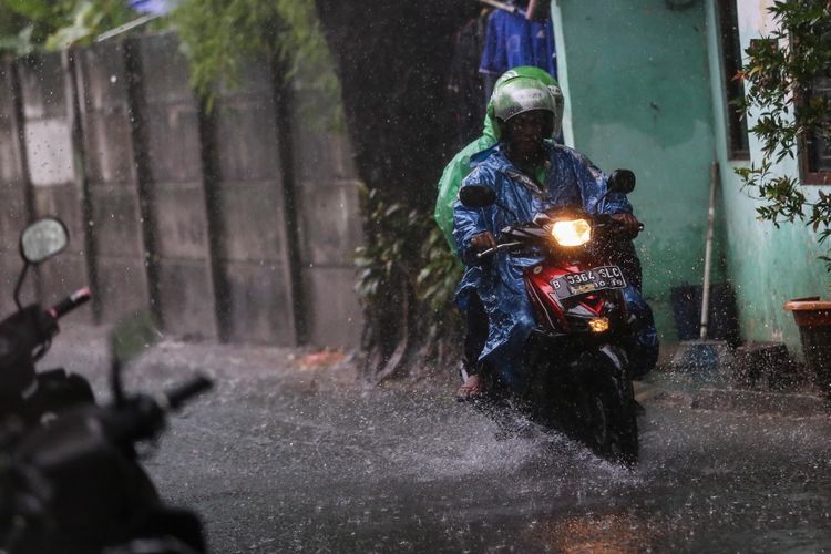 Pengendara sepeda motor melintas dibawah guyuran hujan lebat di jalan Karet Sawah, Jakarta Selatan, Senin (9/10/2017). Curah hujan yang tinggi menyebabkan sejumlah ruas jalan di Ibu Kota tergenang.