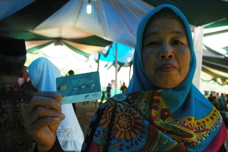 Salah seorang warga Desa Babakan, Kecamatan Ciseeng, Kabupaten Bogor, menunjukkan smart card yang digunakan untuk proses pemilihan kepala desa menggunakan e-voting, Minggu (12/3/2017).