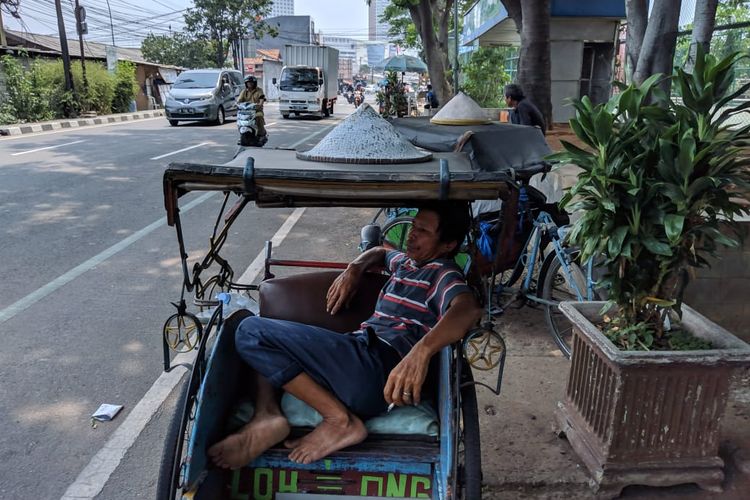 Penarik becak, Kholid saat beristirahat siang menunggu penumpang di Jalan Perintis Kemerdekaan, Kota Tangerang, Senin (18/11/2019).