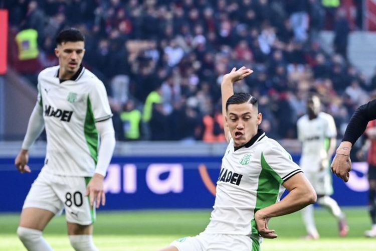 Jay Idzes (kiri) mencoba membendung tembakan Davide Bartesaghi (kanan) dalam laga Liga Italia 2025-2026 AC Milan vs Sassuolo di Stadion San Siro, 14 Desember 2025. (Photo by Piero CRUCIATTI / AFP)