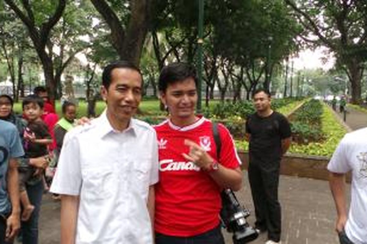 Gubernur DKI Jakarta Joko Widodo tampak sedang melayani ajakan berfoto bersama warga di Taman Suropati, Menteng, Jakarta Pusat, Minggu (21/7/2013).