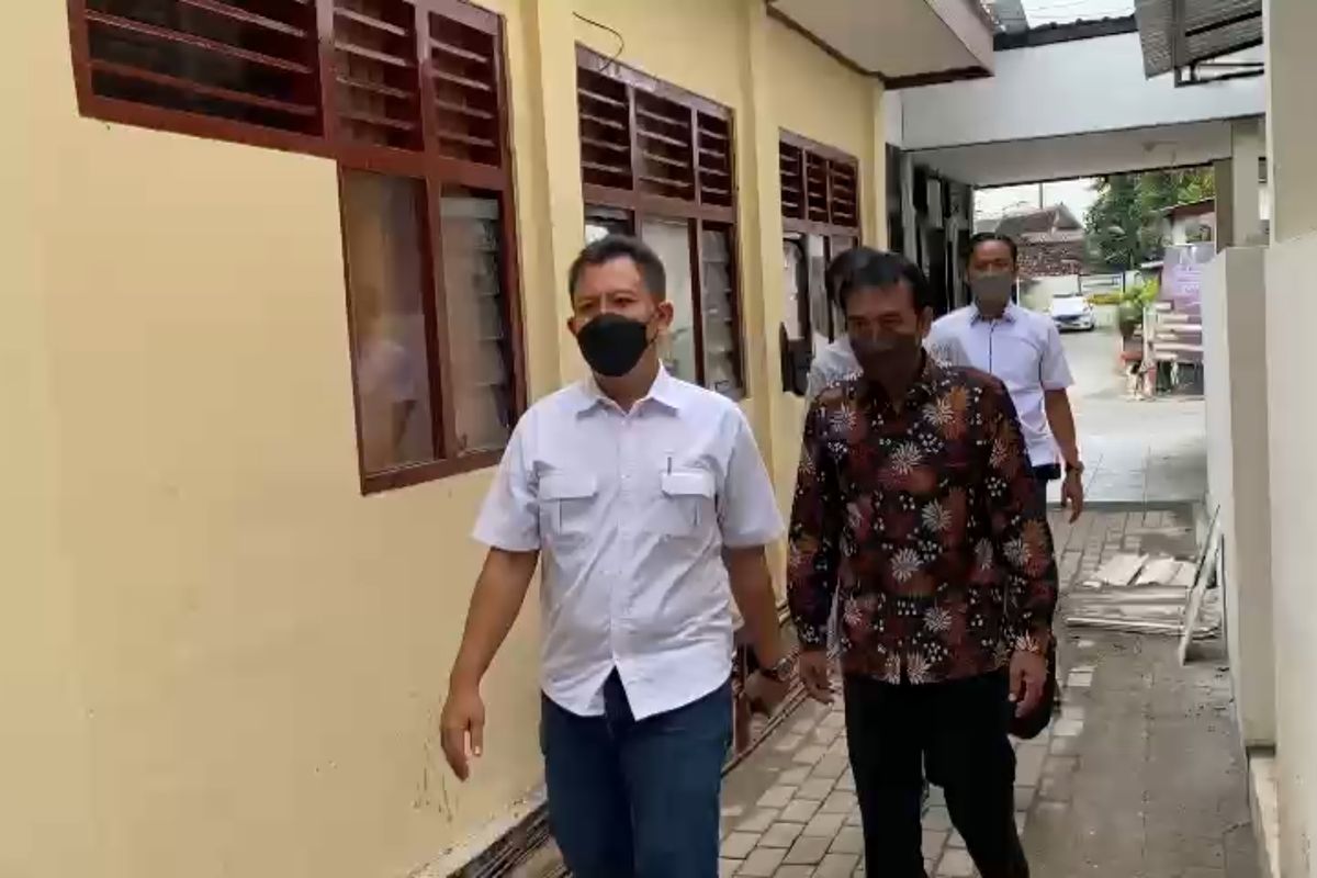 DIPERIKSA—Mantan Kepala Desa Kaligunting, Kecamatan Mejayan, Kabupaten Madiun, NA (berpakaian batik) menuju ruang pemeriksaan unit Tipikor Satreskrim Polres Madiun, Selasa (11/1/2022). 