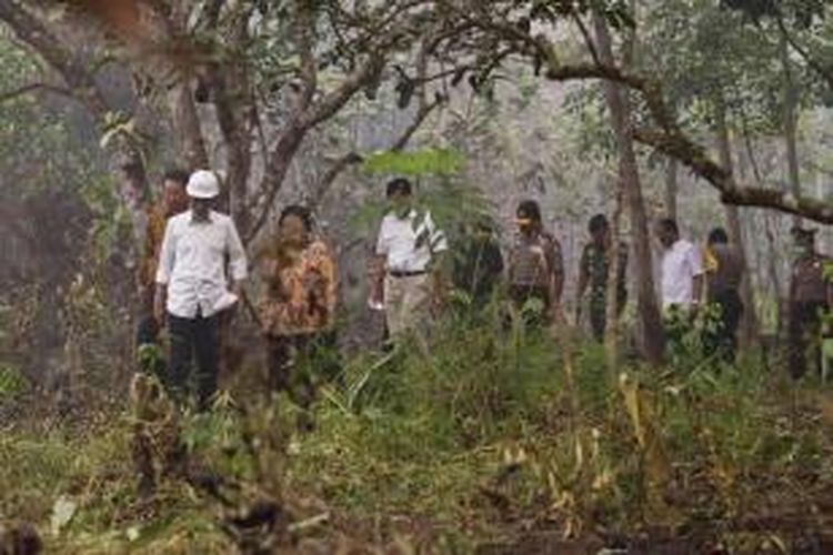 President Joko Widodo (depan), bersama pejabat pemerintah, polisi dan TNI, melakukan inspeksi kebakaran hutan gambut di Kabupaten Kapuas, Kalimantan Tengah, 24 September 2015.