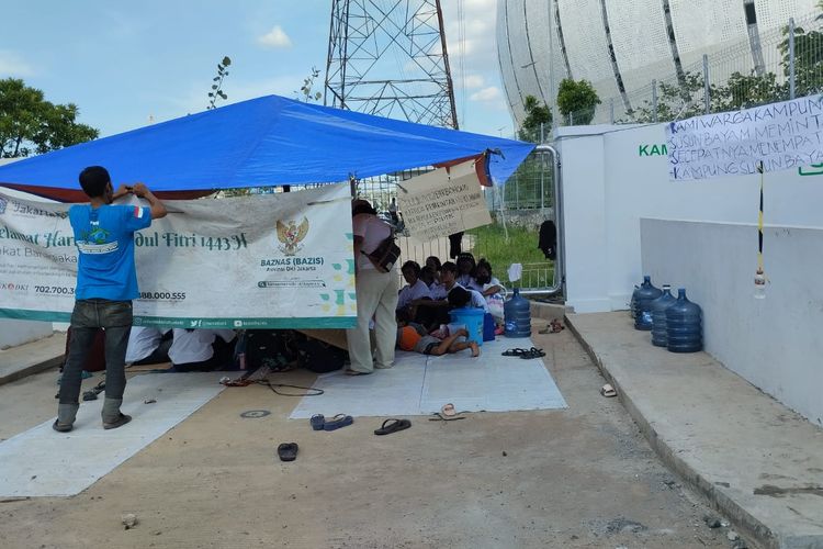 Warga Kampung Susun Bayam membangun tenda dan akan menginap di depan stadion hingga mendapat kepastian menghuni rumah susun (rusun) tersebut, Tanjung Priok, Jakarta Utara, Senin (21/11/2022) 