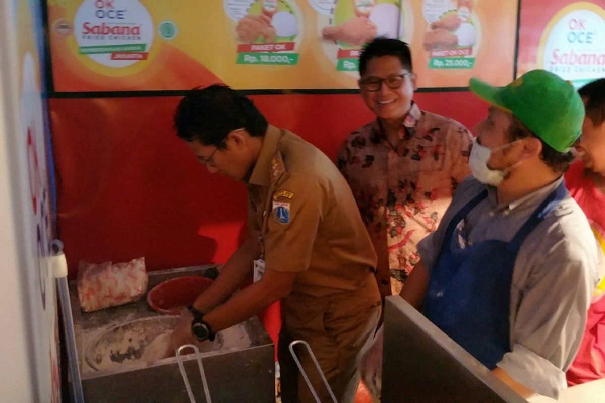 Wakil Gubernur DKI Jakarta Sandiaga Uno mengaduk daging ayam mentah dengan adonan tepung saat berperan sebagai pedagang ayam goreng tepung saat meresmikan kios UMKM di Kantor Kecamatan Tanah Abang, Jakarta Pusat, Selasa (19/12/2017) pagi.