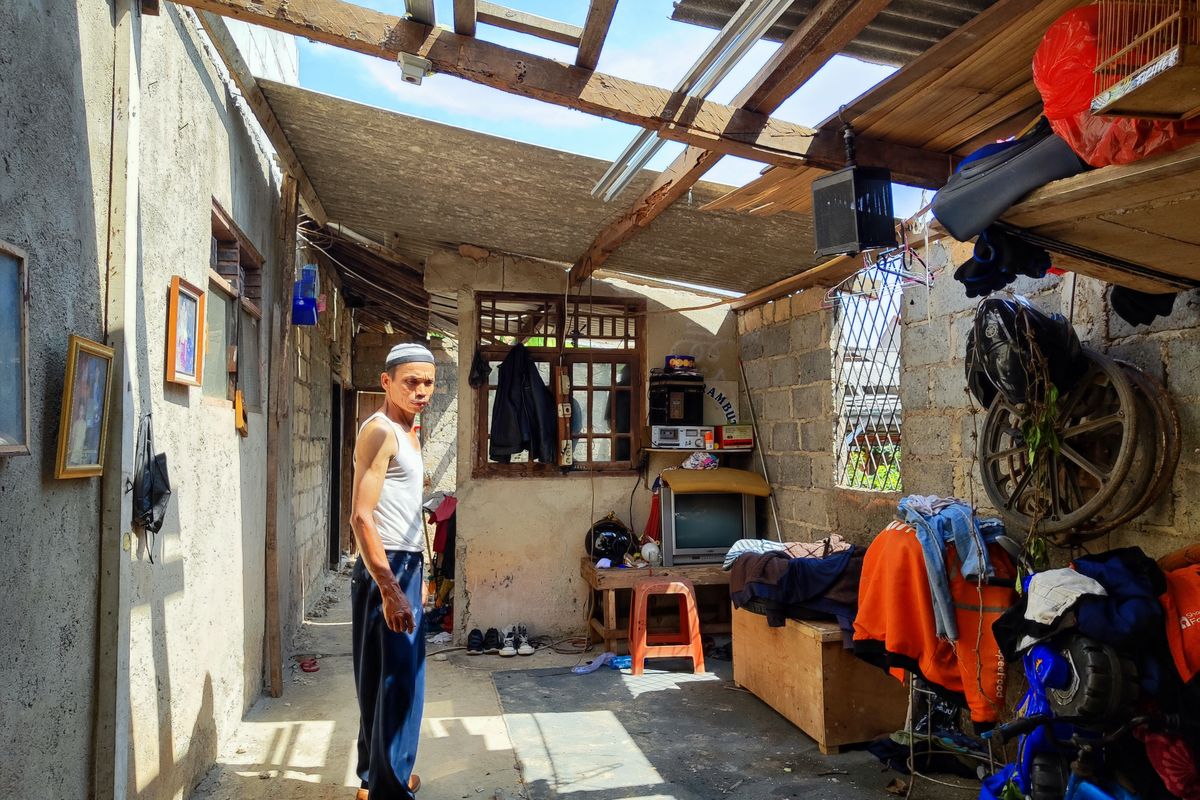 Karim (52) menatap rumahnya yang porak poranda diterjang angin puting beliung, Bedahan, Kota Depok, Jawa Barat, Jumat (15/12/2023). 