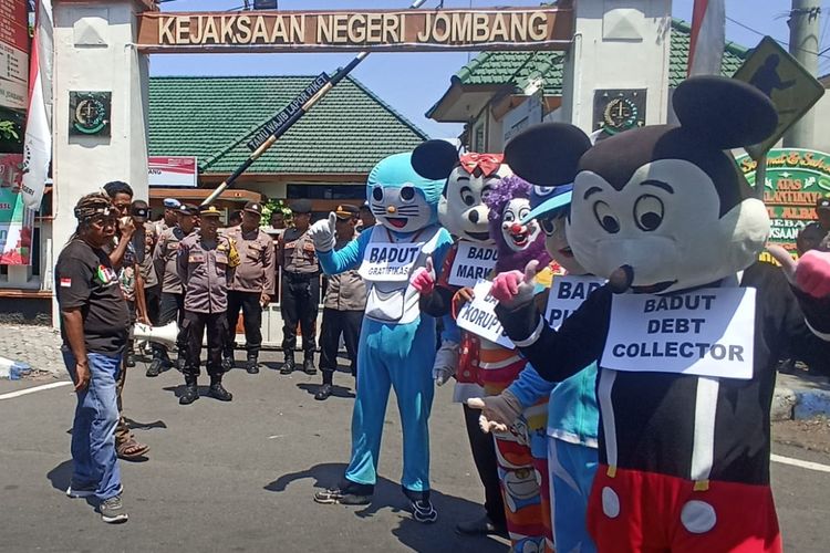 Para badut dan aktivis Forum Rembug Masyarakat Jombang (FRMJ) menggelar aksi demonstrasi di Kantor Kejaksaan Negeri (Kejari) Jombang, Jawa Timur, Selasa (17/9/2024).