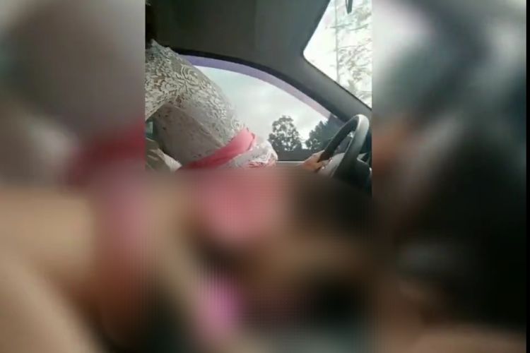 Tangkapan layar video viral pasangan berpakaian adat Bali berbuat mesum di dalam mobil yang sedang melaju. 