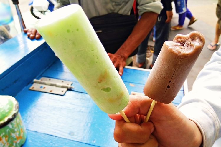 Kompas.com memegang es potong djadoel rasa alpukat (kiri) dan cokelat (kanan) di Pasar Gede, Surakarta, Jawa Tengah, Sabtu (6/3/2021).