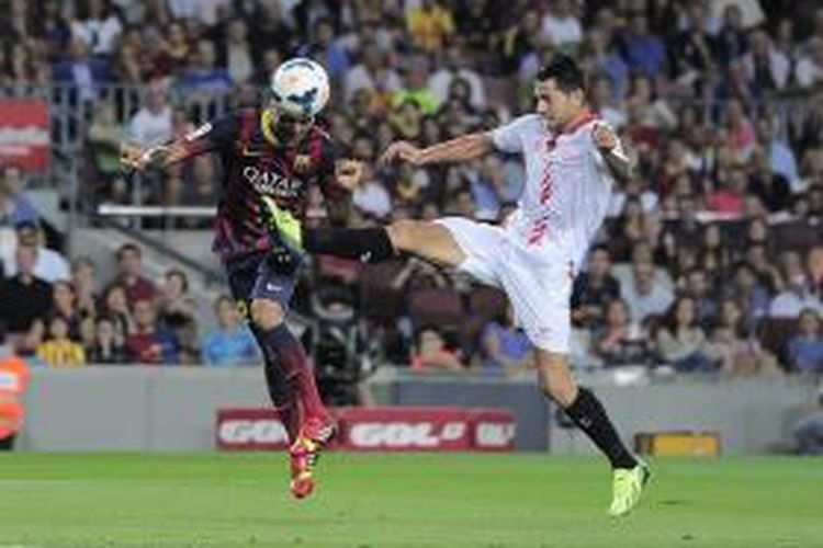 Bek Barcelona asal Brasil, Dani Alves (kiri), berduel dengan gelandang Sevilla, Vitolo, dalam laga La Liga di Camp Nou, Sabtu (14/9/2013. Alves cetak gol lewat sundulan.