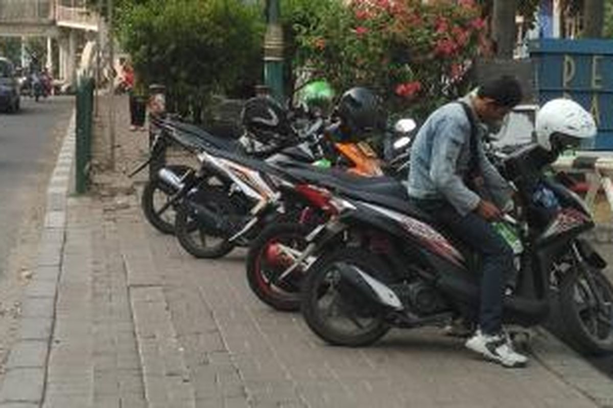 Para pengojek aplikasi memarkir motor mereka di pinggir ruas jalan H R Rasuna Said, Kuningan, Jakarta Selatan, Kamis (1/10/2015).