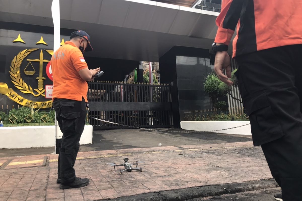 Petugas Inafis dari Mabas Polri menerbangkan drone dalam olah TKP pasca-peristiwa kebakaran gedung Kejaksaan Agung, Kebayoran Baru, Jakarta pada pukul 09.10 WIB.