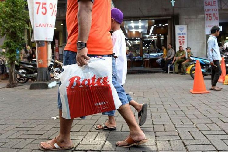 Foto ilustrasi: Seorang pembeli membawa kantong plastik bermerek dari toko Bata, sambil berjalan