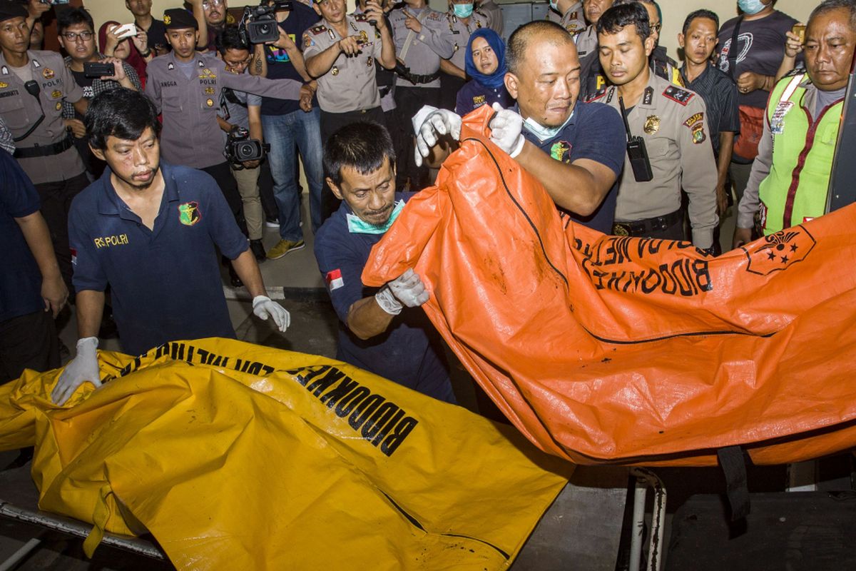 Petugas forensik RS Polri Kramatjati menurunkan jenazah korban kebakaran pabrik kembang api di Instalasi Kedokteran Forensik RS Polri Kramatjati, Jakarta, Kamis (26/10/2017). Petugas medis akan melakukan otopsi terhadap 47  jenazah korban kebakaran di pabrik petasan PT Panca Buana Cahaya Sukses untuk melengkapi proses identifikasi oleh kepolisian.