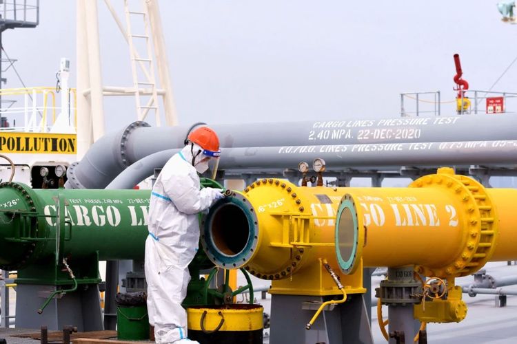 Seorang petugas inspeksi tampak memeriksa tanker yang membawa minyak mentah impor di Pelabuhan Qingdao, di Provinsi Shandong, China, pada 9 Mei 2022.
