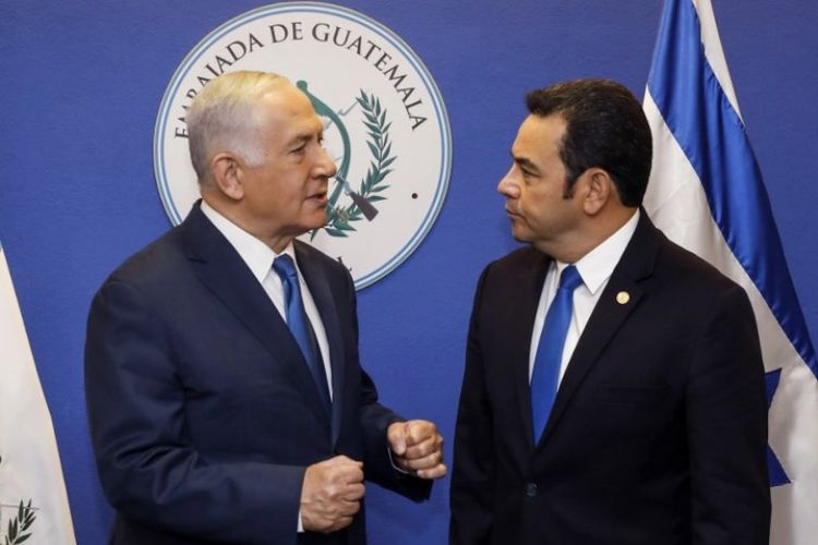 Perdana Menteri Israel Benjamin Netanyahu (kiri) dan Presiden Guatemala Jimmy Morales berbincang dalam acara pembukaan kedutaan besar Guatemala di Yerusalem, Rabu (16/5/2018). (AFP/Ronen Zvulun)