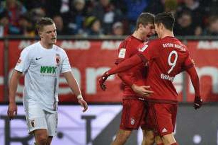 Robert Lewandowski dan Thomas Mueller memborong 3 gol kemenangan Bayern Muenchen di kandang Augsburg, Minggu (14/2/2016).