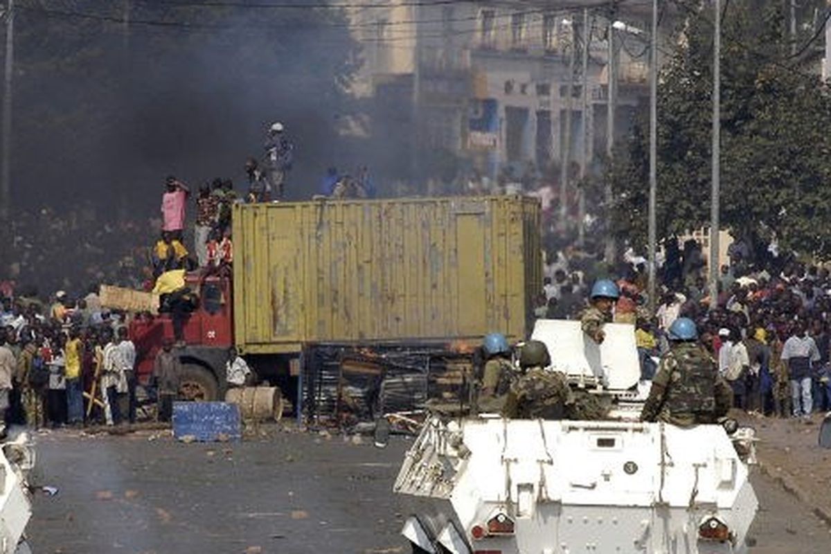 Dalam foto yang diambil pada 9 Juni 2004, beberapa ribu penduduk Kongo di Bukavu tampak berkumpul di depan penghalang jalan MONUC (operasi PBB di Republik Demokratik Kongo) untuk berdemonstrasi menentang PBB dan mendukung kembalinya tentara reguler itu berlari di atas kota dini hari tadi.